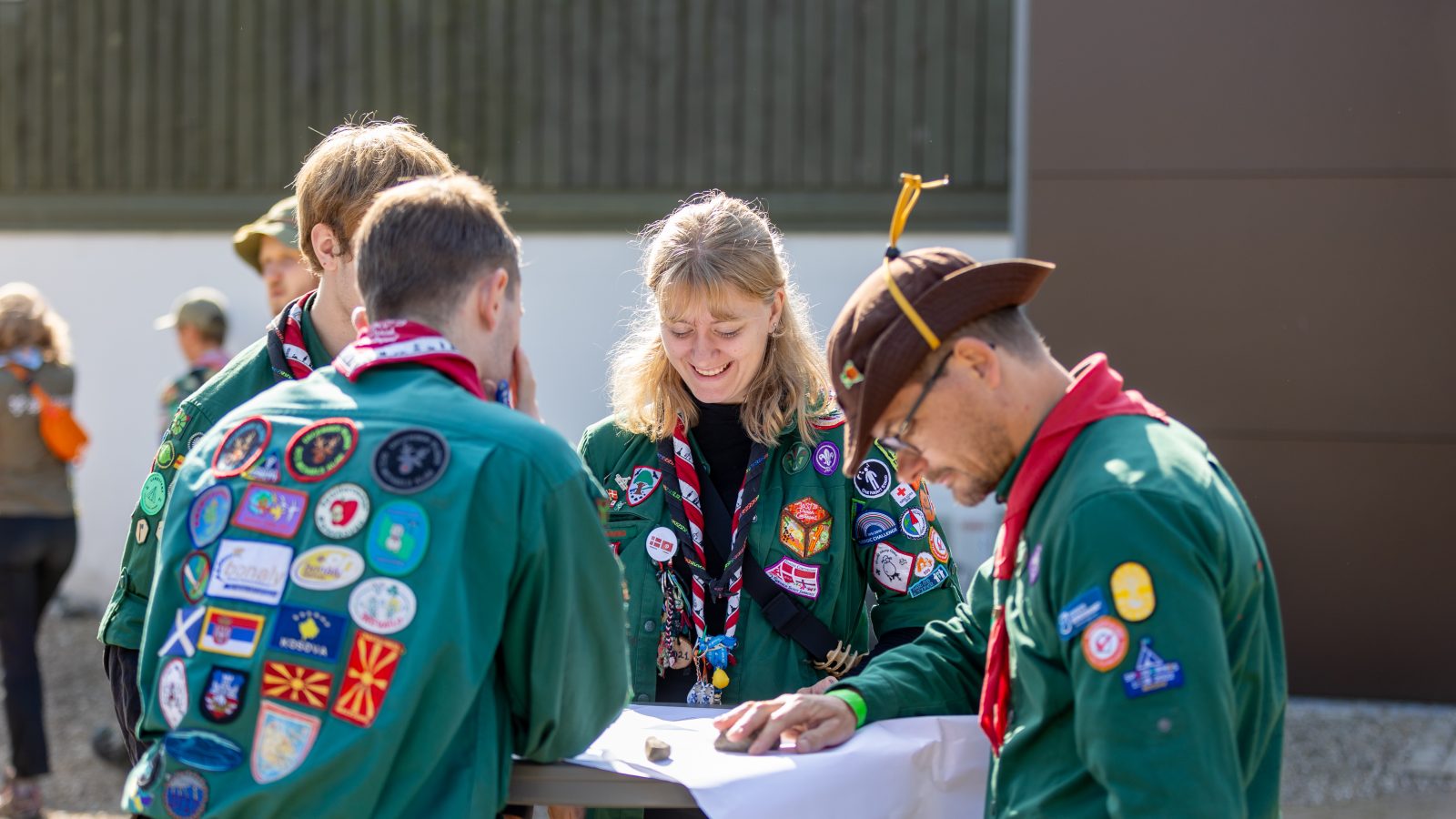 spejdere løser opgaver og snakker sammen.