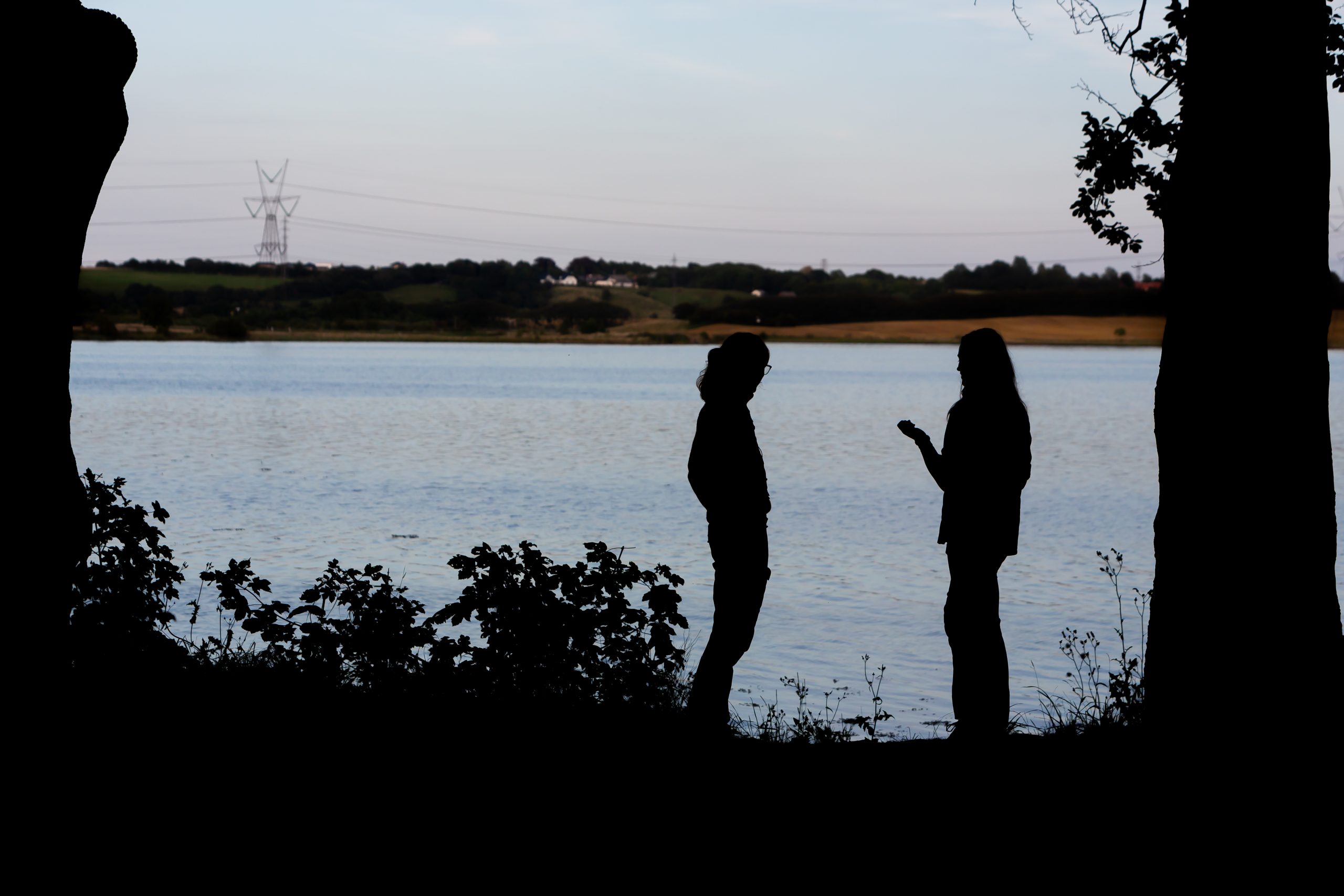 To mennesker taler sammen ved vandet til en korpsweekend