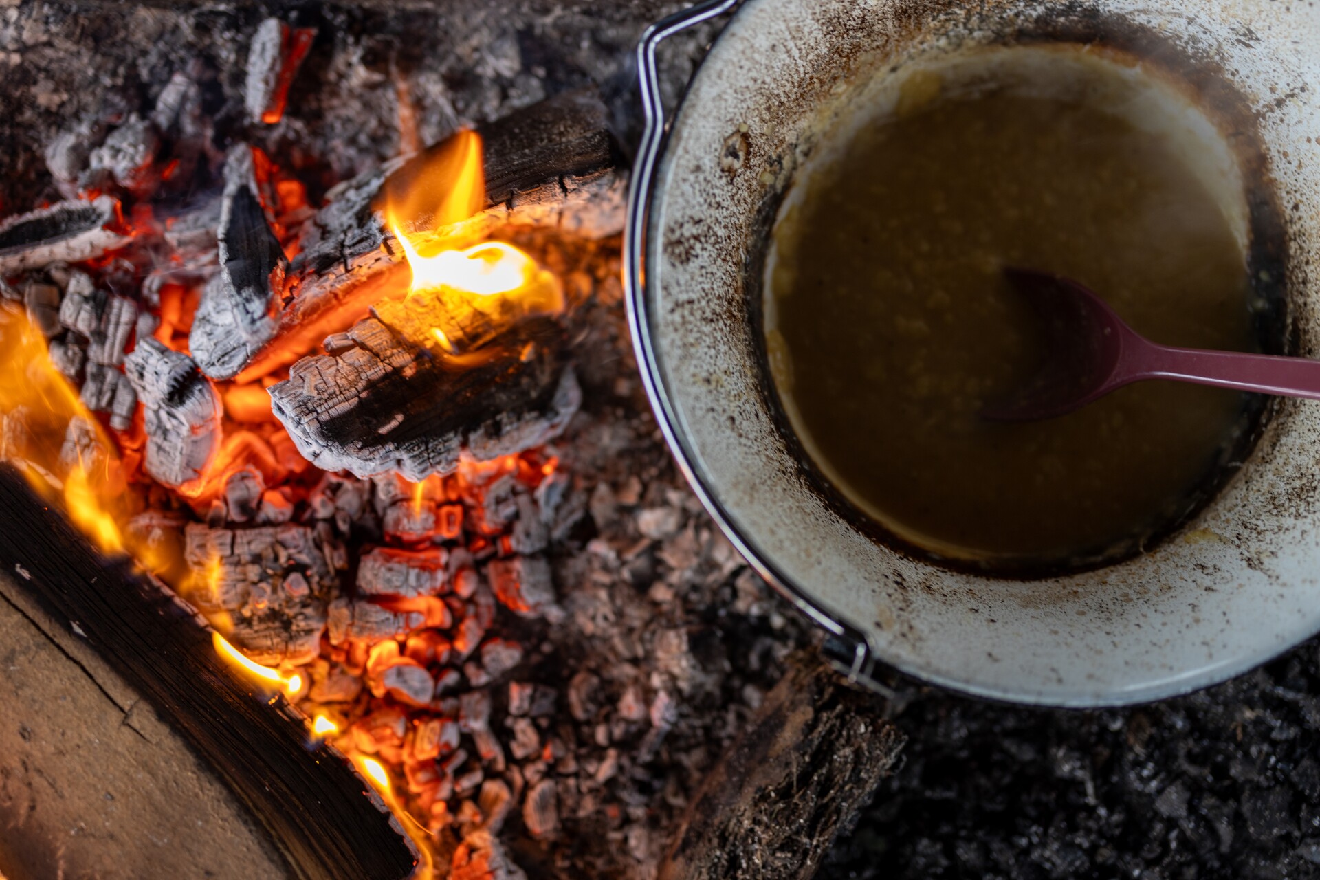 Nærbillede af en gryde over et gløde-bål