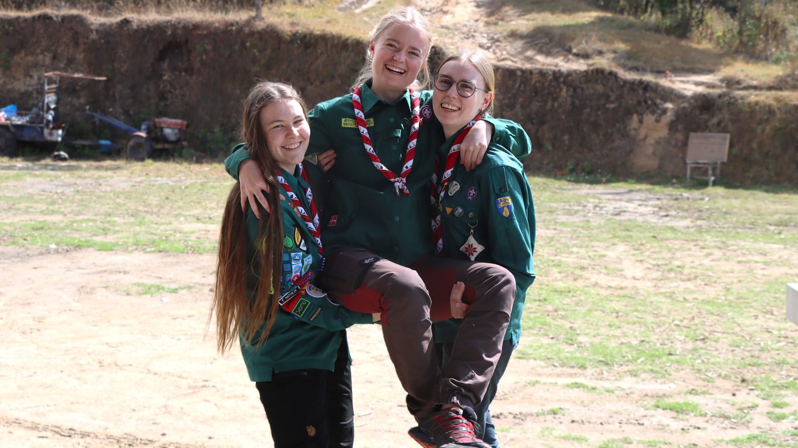 De tre ungdomsledere i Nepal-partnerskabet fra Danmark står tæt på en mark